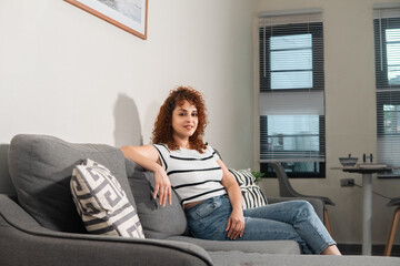 Young woman relaxing on sofa in modern apartment