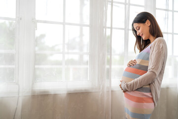 Happy smiling Mother woman hugging and smiling expecting with pregnancy hold baby in belly, woman...