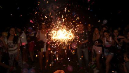 2026 new year with a festive atmosphere, colorful confetti and balloons scattered around, the sparkler held by a person with a big smile, capturing the magic and wonder of the moment,ai generative