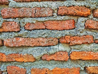 Red brick wall that has been plastered and smoothed with cement
