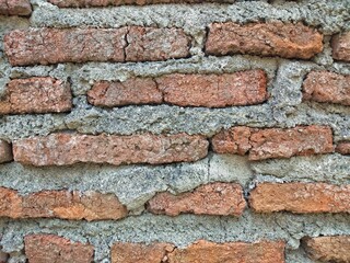 Red brick wall that has been plastered and smoothed with cement