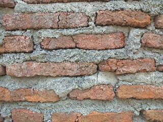 Red brick wall that has been plastered and smoothed with cement