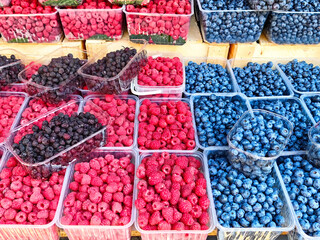Colorful display of fresh berries at a local market stall during summer afternoon