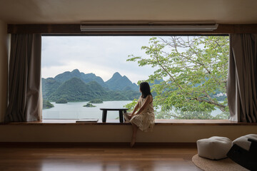 The woman sat on the windowsill, gazing at the scenery outside.
