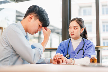 Young man patient stressed and concerned nurse comforting him in clinic room with medical clipboard and stethoscope expressing empathy and calm support