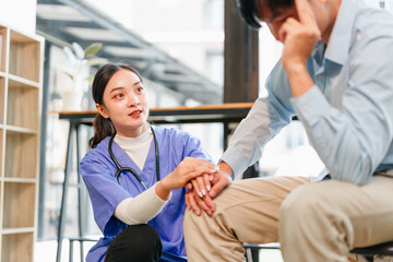 Young nurse comforting distressed patient with supportive hand on knee, empathetic expression...