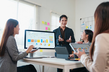 Young professional team meeting with presentation screen showing charts and graphs, collaborative discussion and digital devices in modern office, upbeat atmosphere