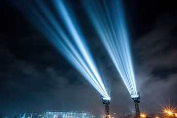 Blue spotlights shining into sky