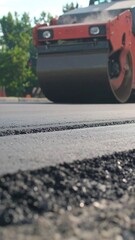 Close-up of road paver working on asphalt