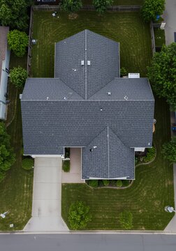 Aerial view of a house with a gray roof and a well-maintained lawn.