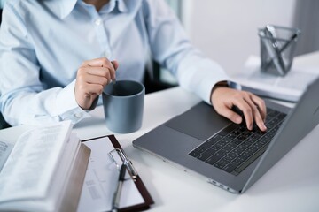 Asian Woman working by using a laptop computer Hands typing on keyboard. Working at office professional investor working new start up project