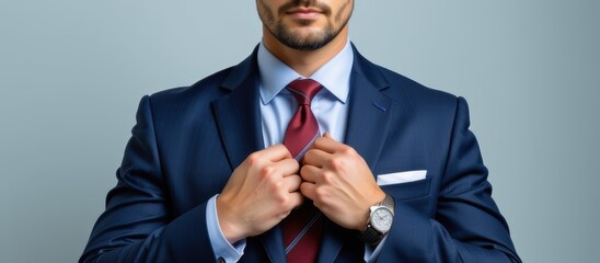 Business professional adjusting tie in formal attire against a neutral backdrop.