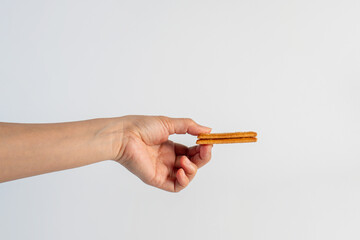 Square cracker in hand on white background