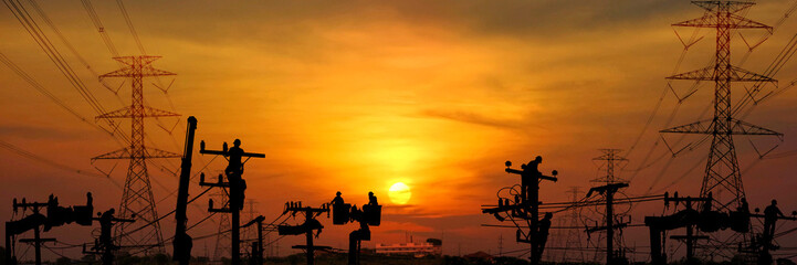 silhouette electric worker work late on electric pole connect the line to high voltage power supply  on sunset abstract nature background
