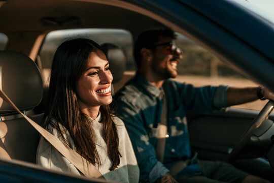 Happy couple enjoying road trip in comfortable car