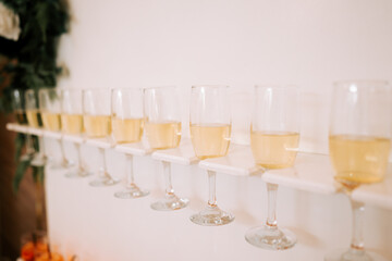 Celebratory drinks lined up on a wooden shelf at a festive event in the evening