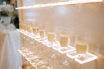 Elegant drinks displayed on a backlit shelf at a celebration event in an upscale venue
