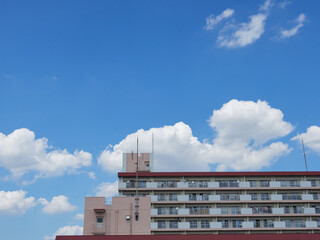 夏の綺麗な青空と住宅地のマンションの風景
