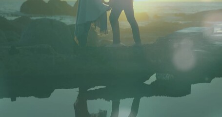 Animation of glowing spots over diverse couple kissing - Powered by Adobe