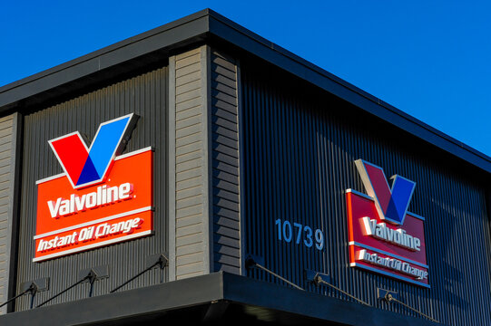 Exterior corner of a Valvoline Instant Oil Change building with two red and blue corporate logo signs, representing an automotive maintenance and service facility for vehicle repair and oil changes
