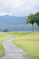 Relax and wellness concept with road in garden and mountain background at chiangmai thailand in raining season