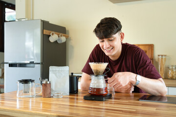Man brewing manual coffee in minimalist kitchen with morning light