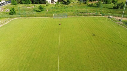 Obraz premium Autonomous sprinkler irrigating soccer training ground in summer