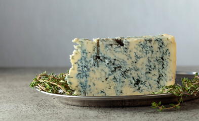 Gorgonzola and thyme on a gray stone table.