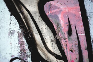 Abstract grunge street art featuring earthy tones and pink hues. 90s, graffiti style, textured surface. Background, urban visuals, contemporary art piece.