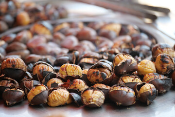 Roasted chestnuts on a metal tray during a market