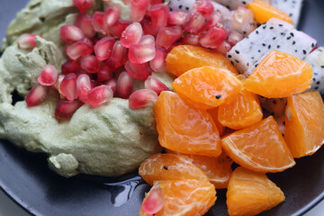 CloseUp view of Greek Yogurt Matcha with Honey, Pomegranate, Orange, Dragon Fruit, Fruit on a Black...