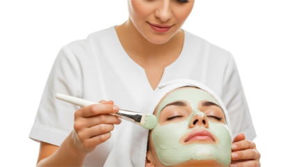 Esthetician applying a green facial mask with a brush, isolated on white background