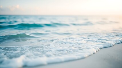 Calm blue ocean waves gently rolling onto a white sandy beach, evoking tropical serenity.