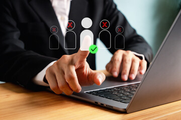 Businessman selecting person icon on virtual screen using recruitment or HR system, representing hiring process, human resources management, and employee selection with digital tools.