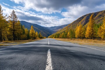Fototapeta premium Scenic view of Chuysky Trakt, passing through yellow larches and mountains of Altai Republic, under a cloudy sky