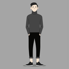 A man in a black sweater and black pants stands in front of a gray background. He has a serious expression on his face