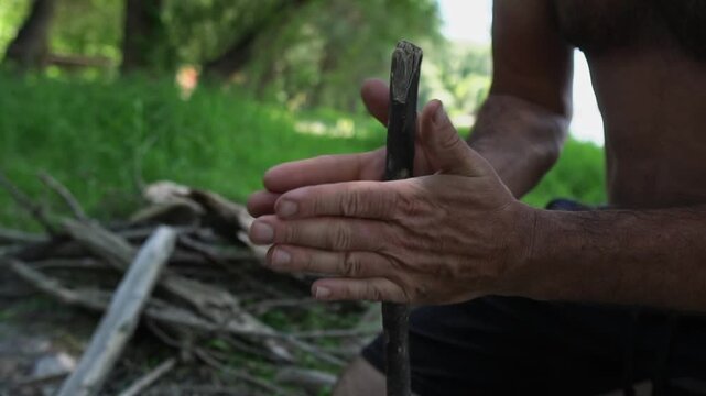 hands of a man, lighting a fire in a primitive way
