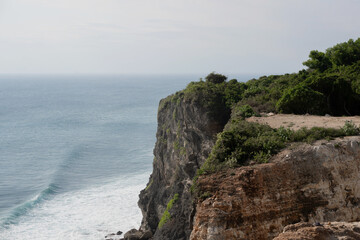 A majestic clifftop covered in green bushes and vegetation, offering a stunning panoramic view of...