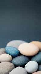 Unique arrangement of smooth pebbles in varying shades placed on a dark background