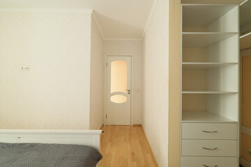A modern minimalist bedroom design featuring both a closet and a door for added functionality