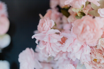 A beautiful close-up of delicate pastel pink flowers, including roses and peonies, captured in soft natural light.