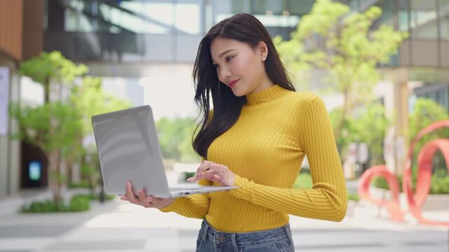Asian young beautiful businesswoman working outdoors in the modern city. 