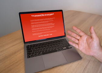 Frustrated user's laptop infected with ransomware demanding a payment. Cybersecurity threat,...