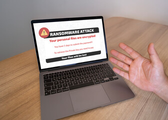 Frustrated user's laptop infected with ransomware demanding a payment. Cybersecurity threat,...