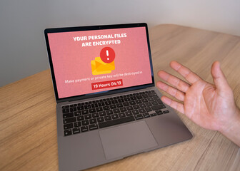 Frustrated user's laptop infected with ransomware demanding a payment. Cybersecurity threat,...
