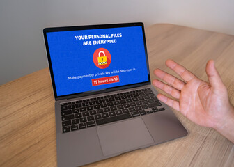 Frustrated user's laptop infected with ransomware demanding a payment. Cybersecurity threat,...