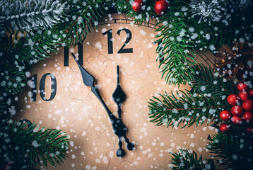 A vintage clock decorated with festive fir branches, red berries, and pinecones shows a few minutes...