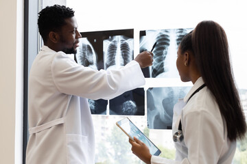 Doctors collaborating near window with X-rays, highlighting medical expertise in diagnostic...