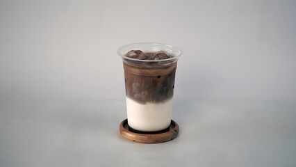 Iced Mocha Beverage with Milk Layer on Wooden Coaster