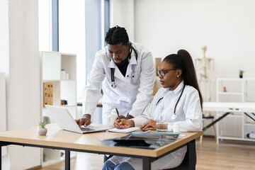 Male and female healthcare professionals collaborating at workplace discussing treatment plans and...